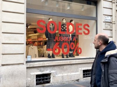 Un toulousain regarde une vitrine affichant les soldes d'hiver 2020 à Toulouse